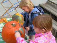 Girls Having Fun Painting Pumpkins