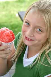 Girl eating a snow come on a hot summer day