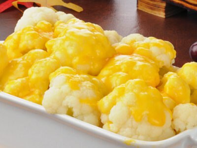 This cheesy cauliflower recipe makes a quick and easy vegetable perfect to serve as a side dish for many popular meals. Its cheesy, tangy flavor and tender texture really makes this cauliflower extra delicious! It's great served with chicken, beef, ham and more!